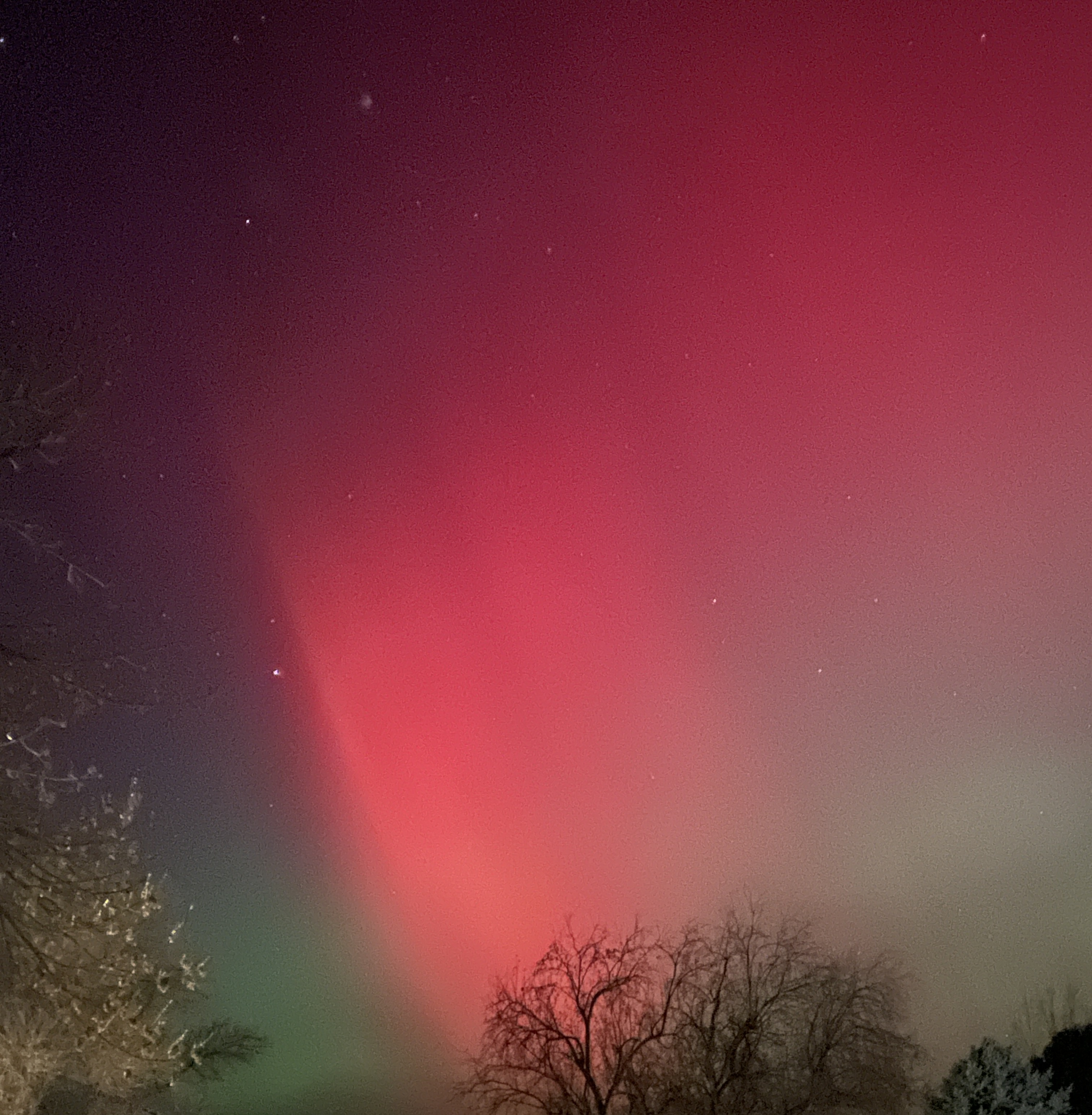 photo of a red aurora in the night sky, a stark border visible